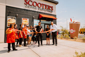Grand opening in front of a Scooters kiosk with the staff cutting a ribbon